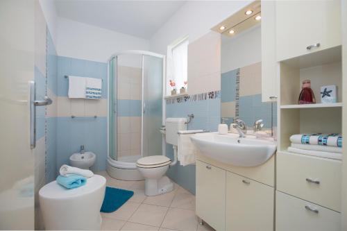 ein Badezimmer mit Waschbecken, Toilette und Dusche in der Unterkunft Gianna Apartment Labin in Labin