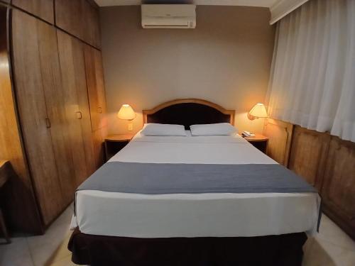 a bedroom with a large white bed with two lamps at Landmark Residence - OFICIAL in Sao Paulo