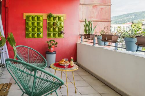 a table and chairs on a balcony with plants at La Ti Tonnelle - Centre et Confort - Wiskeys in Saint-Denis