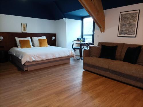 a bedroom with a bed and a couch at Station 14 in Ouddorp