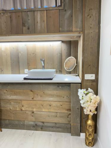 a bathroom with a sink and a vase with flowers at Vernieuwde kamers in het centrum van Brugge in Bruges