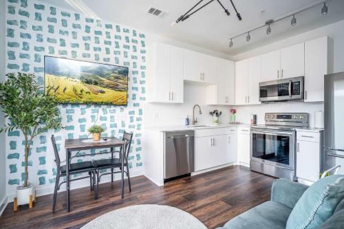 a kitchen with white cabinets and a table at Luxe 1BR w Balcony in Downtown 542Blvd in Atlanta