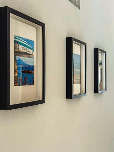 three framed pictures on a wall at Casa Petra in Itri