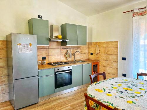 a kitchen with a refrigerator and a table in a room at Appartamento il Lentischio a 5 minuti dal mare a Cardedu in Cardedu