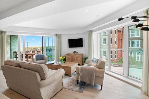 a living room with two couches and a tv at Luxury Apartment very close to Tolcarne Beach in Newquay
