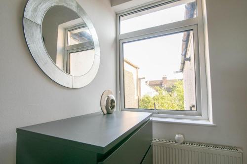 a mirror sitting on the wall next to a window at 3 bed Modern Home, Vibrant & Stylish, Sleep upto 7 in Portsmouth