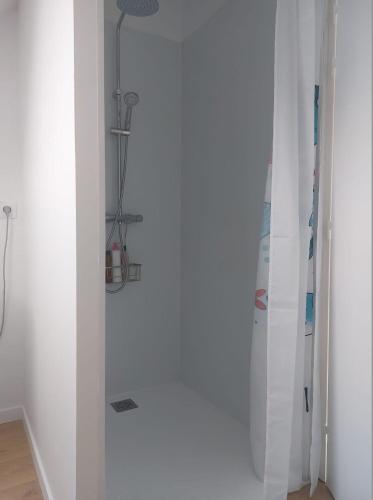 une pièce avec un mur blanc avec un snowboard dans l'établissement Maison Ile de Groix & sa voiture, à Groix