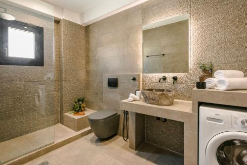 a bathroom with a shower and a sink and a washing machine at KALIMERA Luxurious Villas in Lixouri