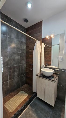a bathroom with a sink and a shower at Complejo Paso de los Andes in Rivadavia