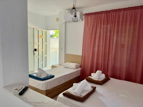 una camera da letto con due letti e una finestra di PELEKAN rooms and apartments athina 11 a Pefkohori