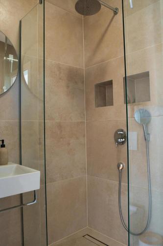 a shower with a glass door next to a sink at Villa Campagna in Trogir