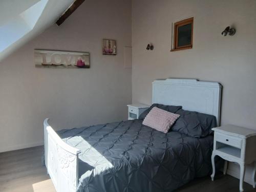 - une chambre avec un lit doté d'un couvre-lit gris dans l'établissement Loubliette, à Laperrière-sur-Saône