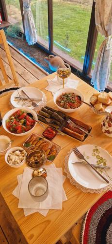a wooden table with plates of food on it at GreenField Resort in Yeghegnadzor