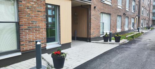 a brick building with several potted plants on a street at Modern studio near Airport with Self check-in in Vantaa