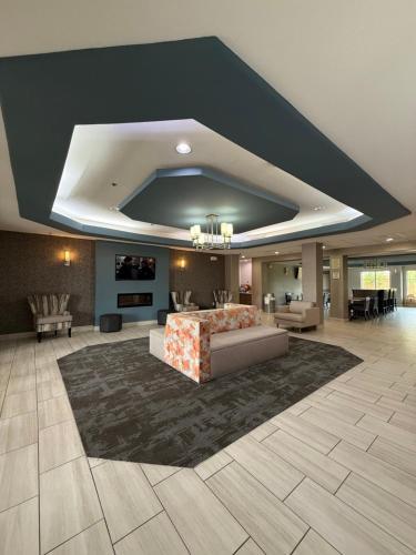 a large living room with a couch and a rug at La Quinta by Wyndham Searcy in Searcy