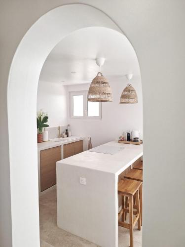 - une cuisine avec un comptoir et un îlot blancs dans l'établissement La P'tite Cigale, à Hyères