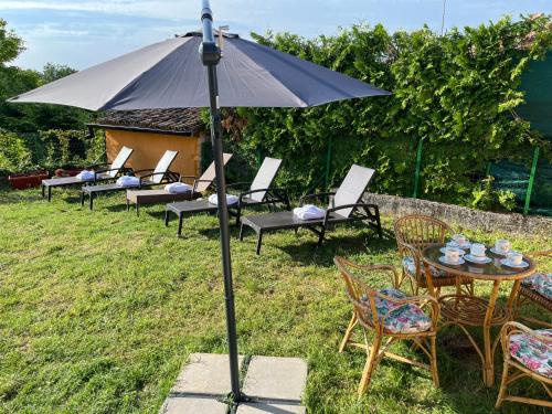 a table and chairs with an umbrella in the grass at Villa Caroiba in Karojba