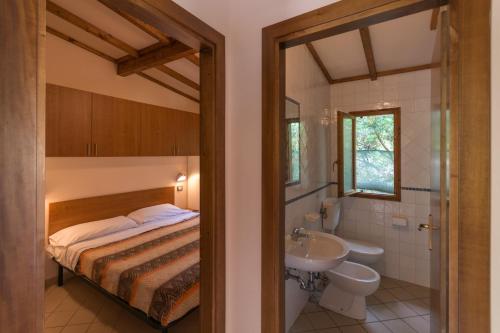 a bedroom with a bed and a sink and a bathroom at Village Camping Hawaii in Albinia