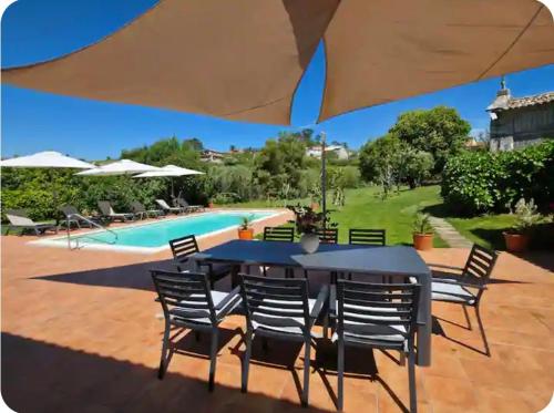 a patio with a table and chairs and a pool at Casa Emilia in Pontevedra