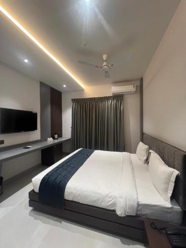 a bedroom with a large bed and a television at Hotel Godwin in Deoghar