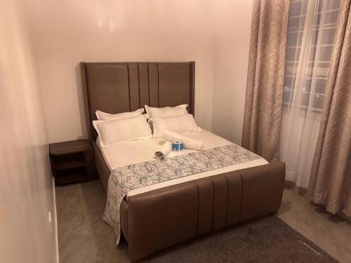 Bett in einem Zimmer mit Sofa und Kissen in der Unterkunft Cozy homes in ruiru, OJ in Gatunga