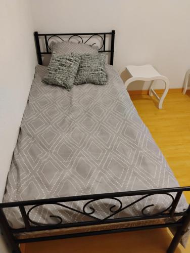 - un lit avec un cadre en métal et des oreillers dans l'établissement Résidence Frontière Basel Airport, à Saint-Louis