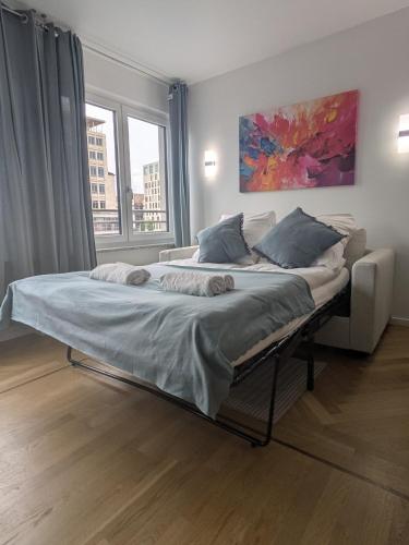 a large bed in a room with two windows at Munich Top Place direkt am Karlsplatz - Stachus 70 qm mit 2 Schlafzimmer Apartment Mila in Munich