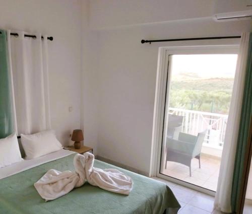 a bedroom with a bed and a large window at Villa Helen's Olive Garden in Xerokampos