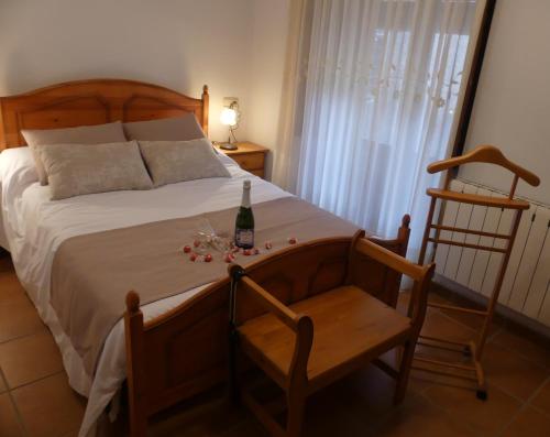 a bedroom with a bed with a bottle of wine and a chair at Casa MI LUCÍA in Moratalla