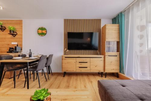 a living room with a television and a dining room table at Englmar Apartments with free WELLNESS and FITNESS in Sankt Englmar
