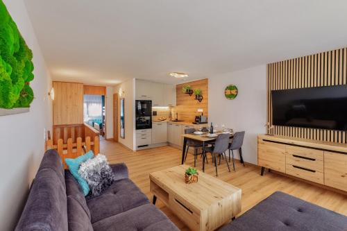 a living room with a couch and a table at Englmar Apartments with free WELLNESS and FITNESS in Sankt Englmar