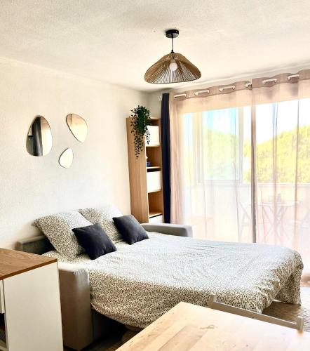 une chambre avec un lit et une grande fenêtre dans l'établissement Appartement cosy à Balaruc, à Balaruc-les-Bains