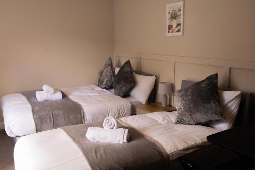 a room with three beds with towels on them at Brand New Studio Gem sleeps 3 in Thornton Heath