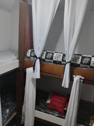 a couple of bunk beds in a room with curtains at Cabana Hostel Guarulhos in Guarulhos