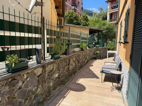 a stone wall with a bench and a fence at Camere Margot in Monterosso al Mare