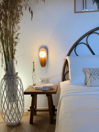 une chambre avec un lit et une table avec une lampe dans l'établissement WABI SABI SUITE by ZARA, à Villasimius