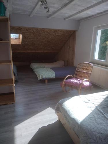 Cette chambre comprend 3 lits et une chaise. dans l'établissement Gite a la ferme La Fée Milie, à La Bourgonce