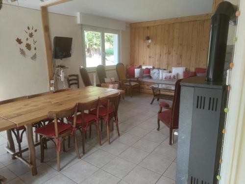 une salle à manger avec des tables et des chaises en bois dans l'établissement Gite a la ferme La Fée Milie, à La Bourgonce