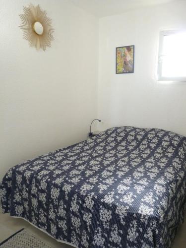 une chambre avec un lit avec une couverture bleue et blanche dans l'établissement Beau 2 pièces, très belle vue mer, à Six-Fours-les-Plages