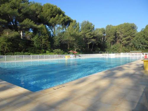 une piscine avec de l'eau bleue et des arbres en arrière-plan dans l'établissement Beau 2 pièces, très belle vue mer, à Six-Fours-les-Plages