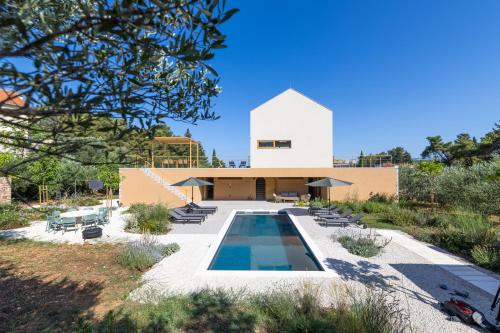 a house with a swimming pool in front of a building at Nine Olives Hvar in Stari Grad