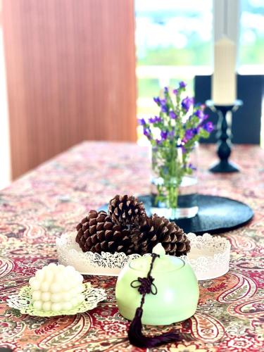 a table topped with plates of pine cones and candles at Coastal Breeze Villa in Sesimbra in Sesimbra