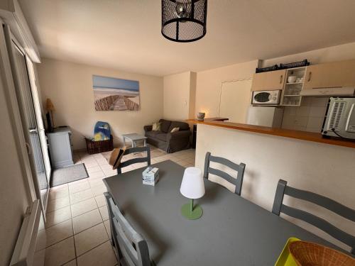 a kitchen and living room with a table in a room at Villa de 6 pers, 500m plage. in Soulac-sur-Mer