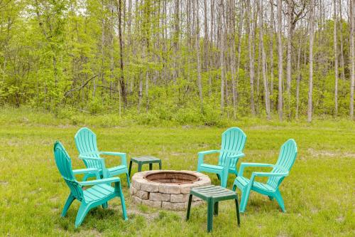 a group of four chairs around a fire pit at Higgins Lake Barndominium with Boat Parking! in Higgins Lake