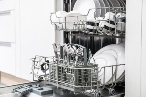 a dishwasher with plates and dishes in it at POOL & SPA - wellness VILLA St Martin in Mġarr