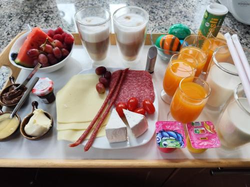 a tray of food with cheese and fruit and glasses of milk at Ferienwohnung Schlabbeflicker Pirmasens in Pirmasens
