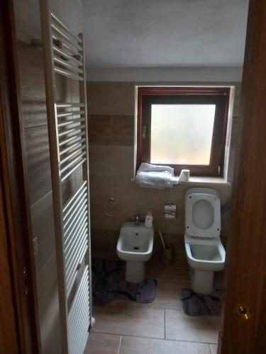 a bathroom with a sink and a toilet and a window at B&B La Pace in Livorno Ferraris