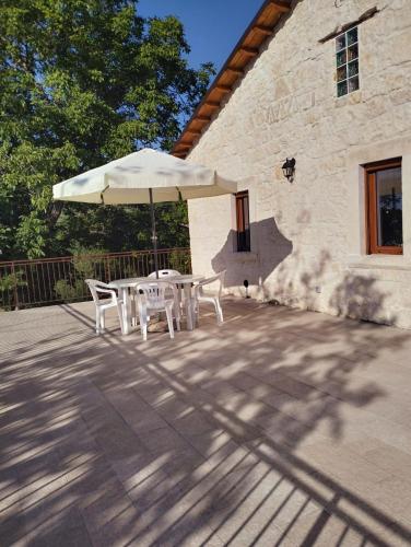a table and chairs with an umbrella on a patio at Casa Rurale Pietra Bianca in Roccamorice