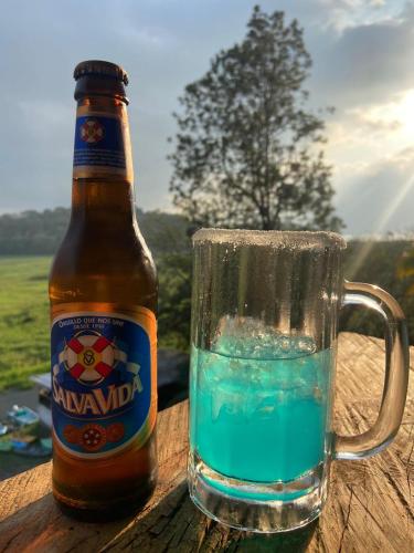 a bottle of beer next to a glass of water at cabañas agua azul in Santa Cruz de Yojoa