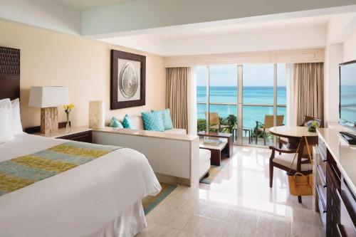 a hotel room with a bed and a view of the ocean at Grand Fiesta Americana Coral Beach Cancun - All Inclusive in Cancún